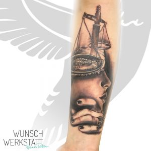 Tattoo mit Waage und Gesicht